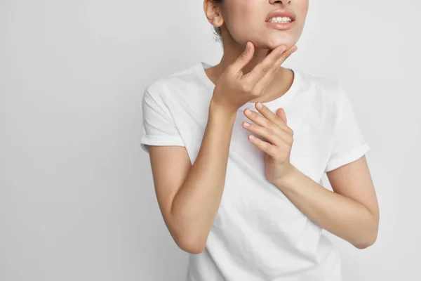 Mulher em t-shirt branca segurando dor facial nos dentes problemas de saúde tratamento — Fotografia de Stock
