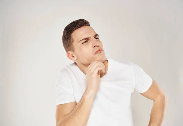 Man with pensive facial expression in white t-shirt emotions isolated background — Stock Photo, Image
