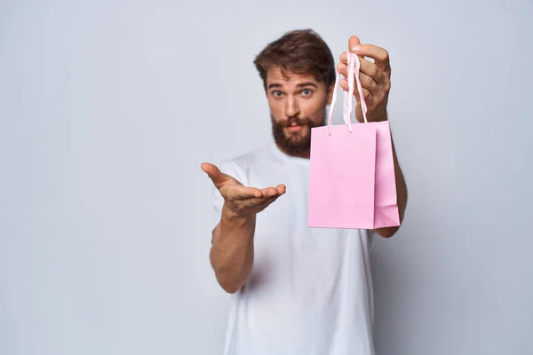 Homme en blanc t-shirt rose paquet cadeau montre un autre — Photo
