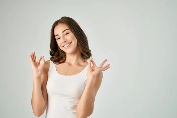 Χαρούμενα μελαχρινή gesturing με τα χέρια της σε ένα λευκό t-shirt πρότυπο τρόπο ζωής — Φωτογραφία Αρχείου