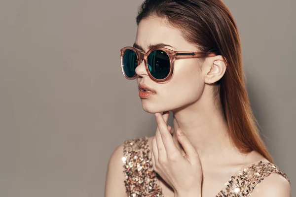 Mulher atraente usando óculos de sol vestido dourado decoração modelo estúdio — Fotografia de Stock