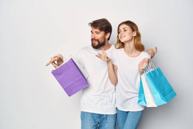 Ellerinde paketler olan kadın ve erkek eğlence yaşam tarzı indirimi yapıyorlar.