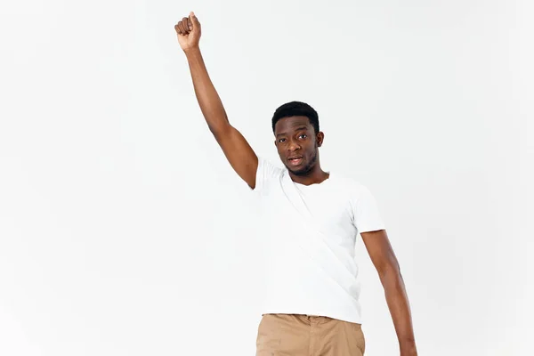 Homme africain apparence blanc t-shirt tenir sa main au-dessus de sa tête arrière-plan clair — Photo