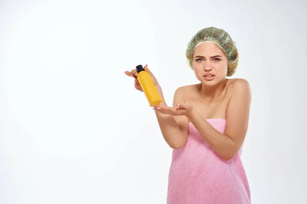 Femme en bocal jaune serviette rose avec crème soin du corps — Photo