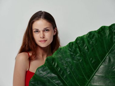 Kırmızı tişörtlü çekici bir kadın. Kızıl saçlı. Temiz ciltli.