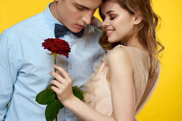 Jeune couple câlins romance passion rose fleur jaune fond — Photo