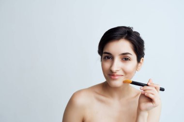 Esmer, çıplak omuzlu, makyajlı.