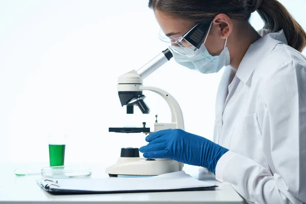 Donna scienziata guardando attraverso un microscopio ricerca biologia diagnostica — Foto Stock