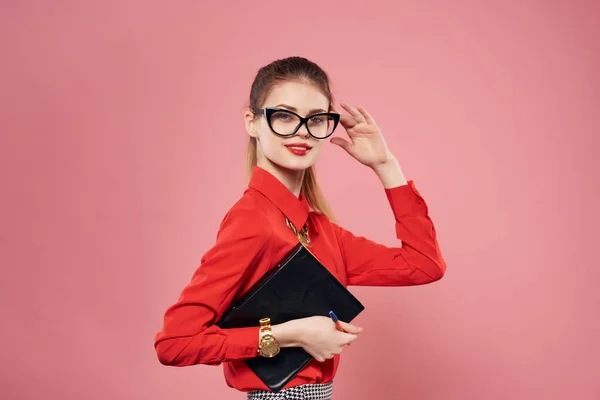 Woman in red shirt and glasses documents in hands of secretary pink background — Stock Photo, Image