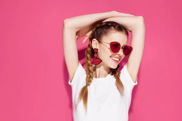 Vacker kvinna bär solglasögon glamour flätor livsstil mode rosa bakgrund — Stockfoto