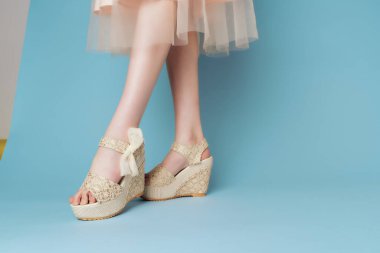 Ayakkabılı kadın bacakları. Kesik açılı mavi arka plan modası.