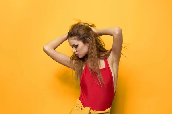 Красива жінка в червоній футболці косметика прикраса моди жовтий фон — стокове фото