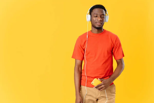 Αφρικανός που φοράει ακουστικά ακούγοντας μουσική τεχνολογία κίτρινο φόντο — Φωτογραφία Αρχείου