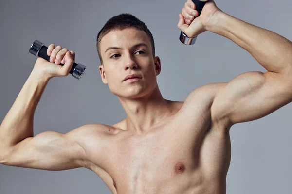 Homme sportif avec haltères dans les mains biceps exercice force vue recadrée — Photo