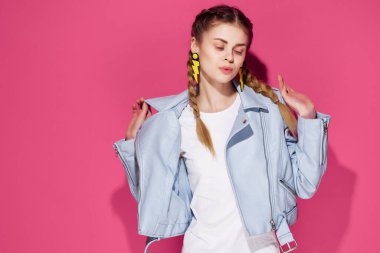 Saçları örgülü neşeli genç bir kadın. Gençlik takısı takıyor.