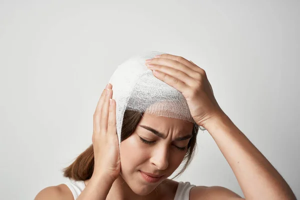 woman with headache bandaged head discomfort trauma