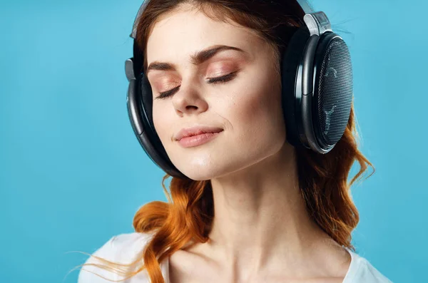 Mujer con auriculares escuchando música entretenimiento tecnología moda fondo azul —  Fotos de Stock