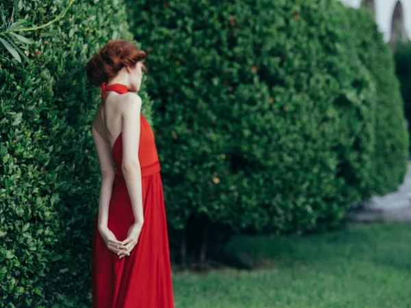 Γυναίκα σε κόκκινο φόρεμα κομψό στυλ κήπο φύση θέτοντας — Φωτογραφία Αρχείου