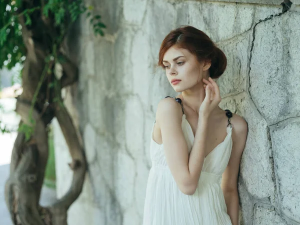 Hübsche Frau in weißem Kleid posiert in der Natur in der Nähe eines Baumes Griechenland — Stockfoto