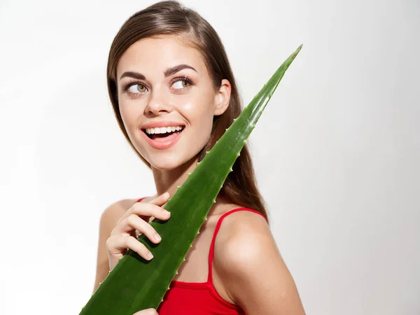 Festa mulher feliz com folha de aloés verde no fundo claro e modelo de vista cortada — Fotografia de Stock