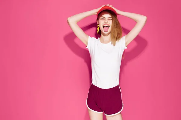 Csinos nő nyári ruhák egy sapka a fején divat szórakoztató rózsaszín háttér — Stock Fotó