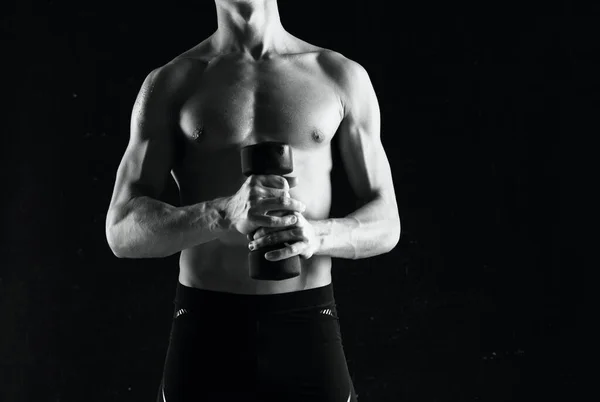 Sportovní muž s činkami v rukou pumpování svaly cvičení tmavé pozadí — Stock fotografie