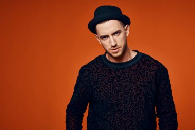 Moda stüdyosu tarzında siyah kazaklı bir adam.