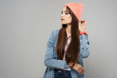 Pembe şapkalı kadın elini stüdyonun yanında tutuyor.