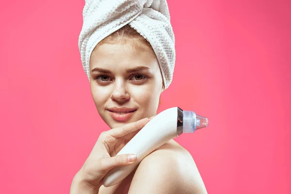 Kobieta z ręcznikiem na głowie czyszczenie skóry nagie ramiona różowe tło — Zdjęcie stockowe