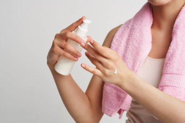 Omuzlarında havlu olan kadın cilt losyonu spa tedavileri temiz cilt