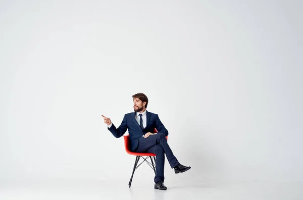 Homme d'affaires en costume assis sur chaise rouge émotions bureau — Photo