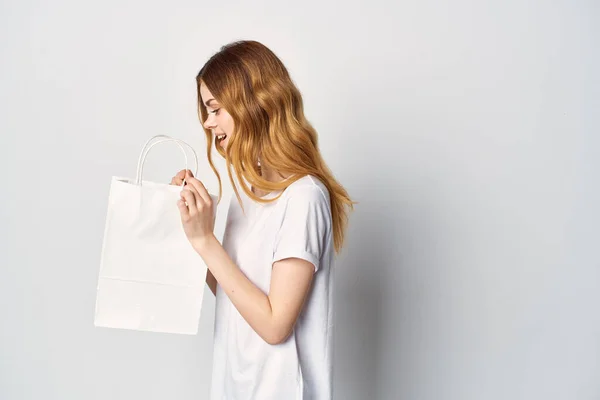 Женщина в футболке в руках, покупает в магазине — стоковое фото