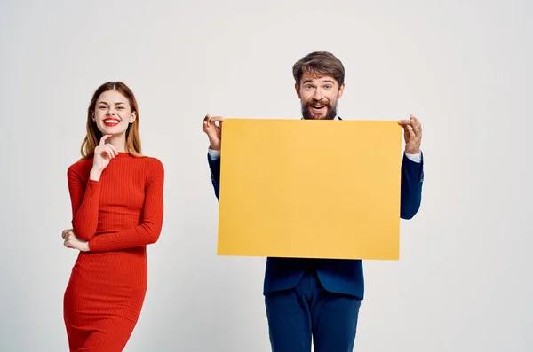 Homme et femme debout à côté de la publicité posant rabais — Photo