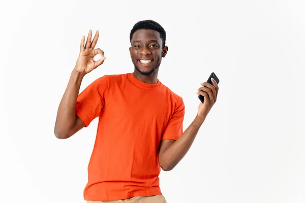 Cheerful man of African appearance with a phone in the hands of technology communication — Fotografia de Stock
