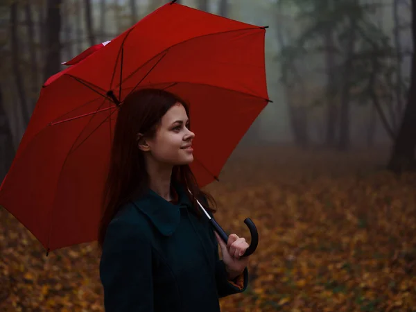 Donna con ombrello rosso cappotto autunno foresta nebbia natura — Foto Stock