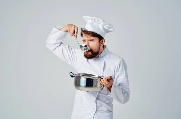 Chef masculino profissional com uma panela em suas mãos saboreia restaurante de comida — Fotografia de Stock