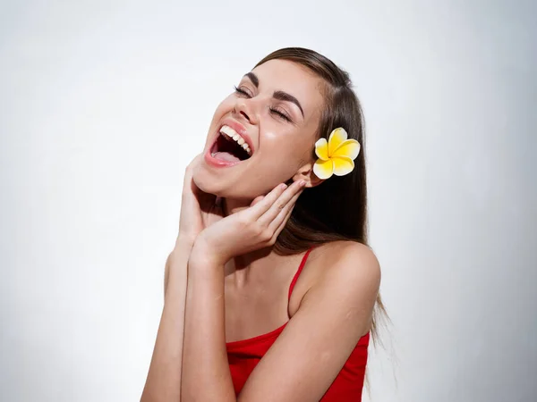 Beautiful young woman touches her face with her hands and opened her mouth wide yellow flower in her hair —  Fotos de Stock