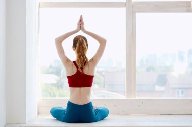 Pencere kenarındaki kadın yoga egzersiz meditasyon gevşemesi