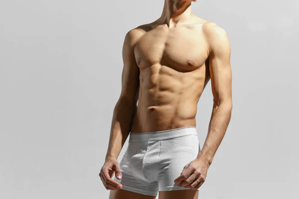 Hombre deportivo en pantalones cortos blancos inflado torso posando atleta de moda — Foto de Stock