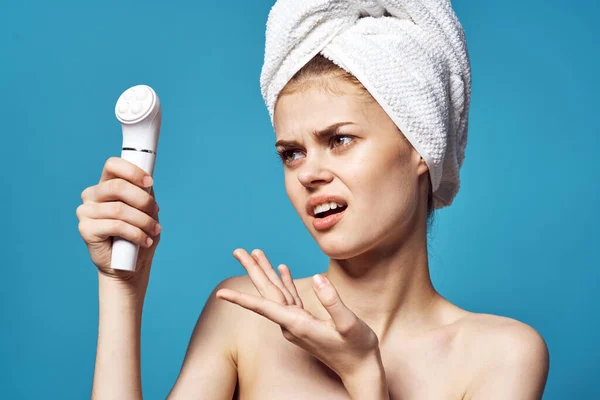 Fröhliche Frau mit einem Handtuch auf dem Kopf des Massagegeräts in ihren Händen Hautpflege — Stockfoto