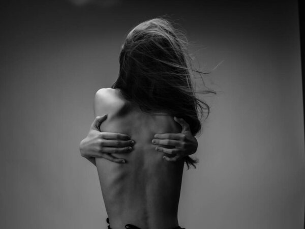 женщина держит руки на спине вид сзади черно-белый фото