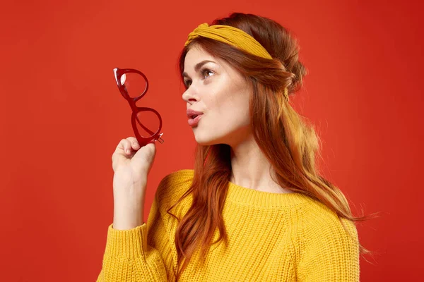 Aantrekkelijke vrouw met geel verband bril in de handen van Studio accessoires — Stockfoto