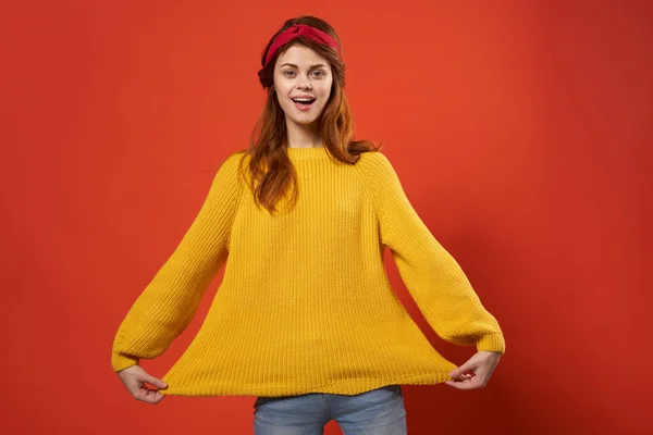 노란 스웨터를 입고 밝고 아름다운 여인 이 스튜디오 장식을 다시 하는 모습 — 스톡 사진