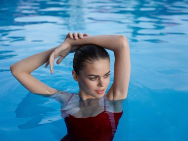 Havuz tatilinde kırmızı mayo giyen güzel bir kadın. 