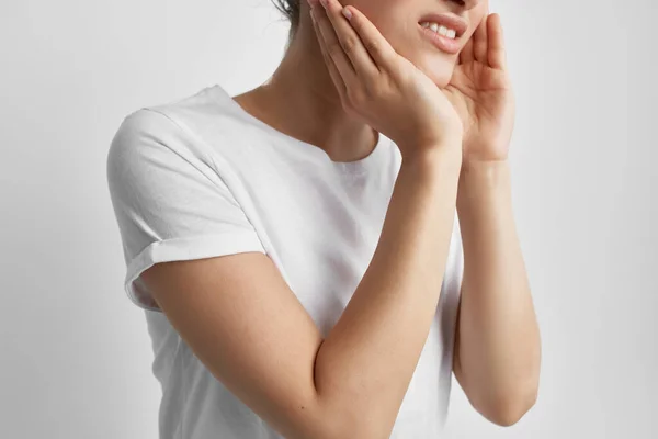 Γυναίκα σε λευκό t-shirt κρατώντας τον πόνο στο πρόσωπο σε προβλήματα υγείας των δοντιών θεραπεία — Φωτογραφία Αρχείου