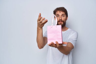 Sakallı adam pembe paket hediye yaşam tarzı gösteriyor.