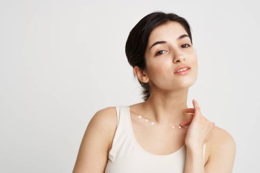 Vücudunda krem olan beyaz tişörtlü kadın cilt temizliği yapıyor.