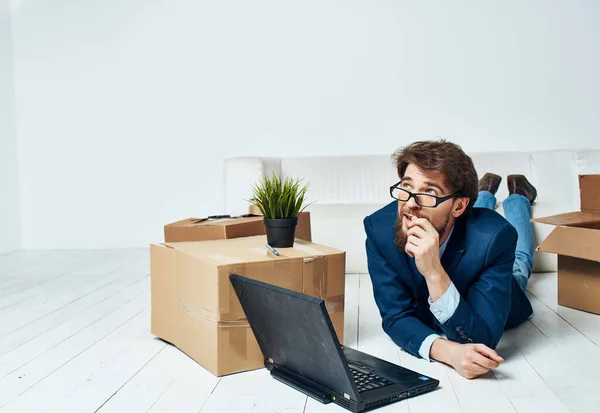 Un homme bon marché se trouve sur le sol devant un bureau d'ordinateur portable changer de lieu de travail — Photo