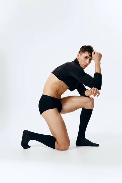 Jong brunette man poseren op een lichte achtergrond in een trui, shorts en sokken — Stockfoto