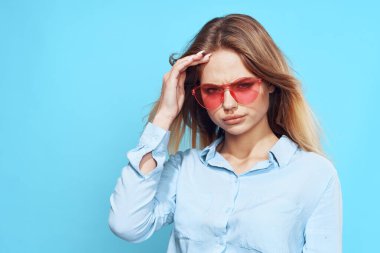Stüdyo mavisi arka planda pembe gözlüklü güzel sarışın